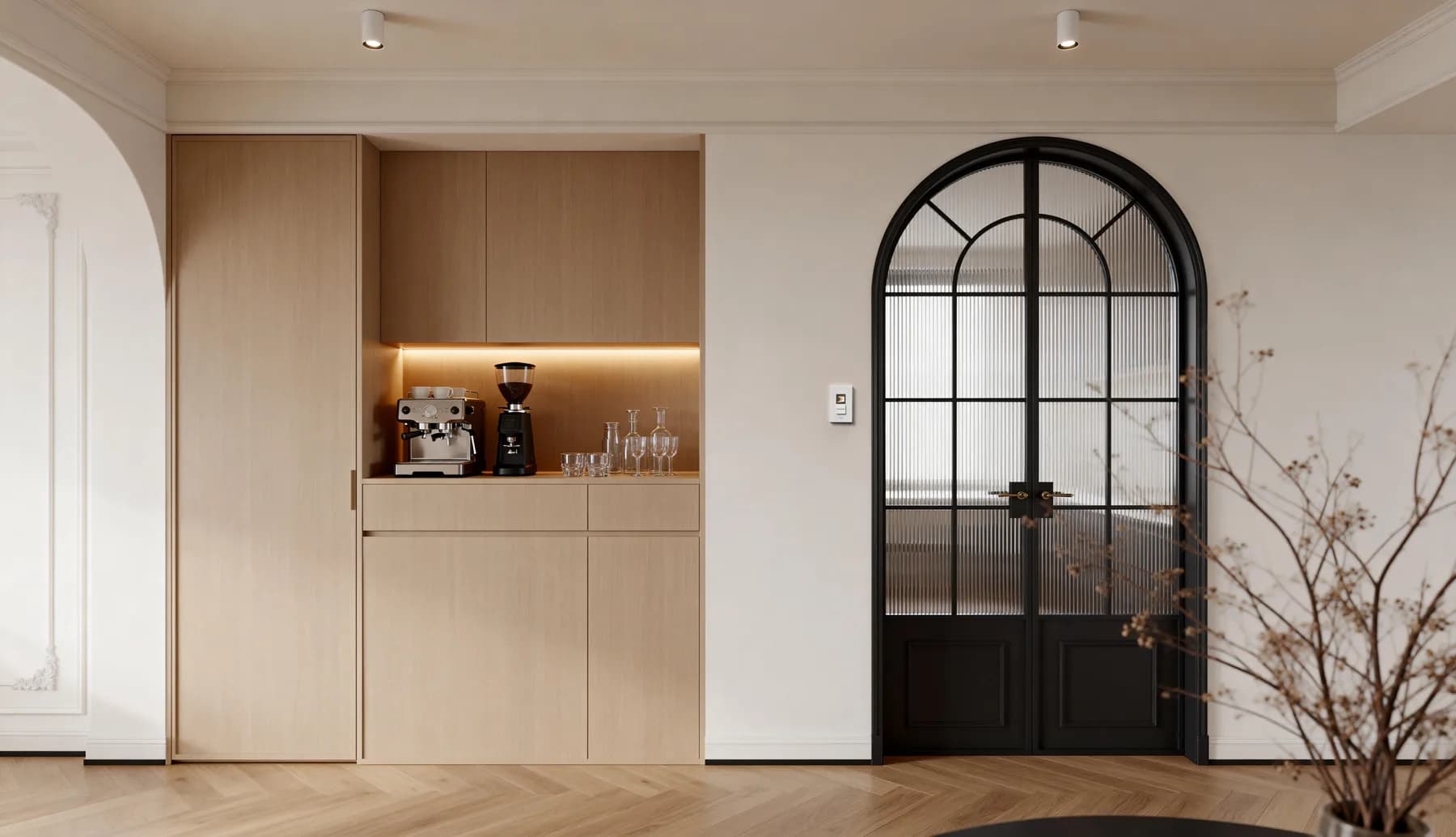 Neutral interior with pale timber cabinetry and a black arched glass door