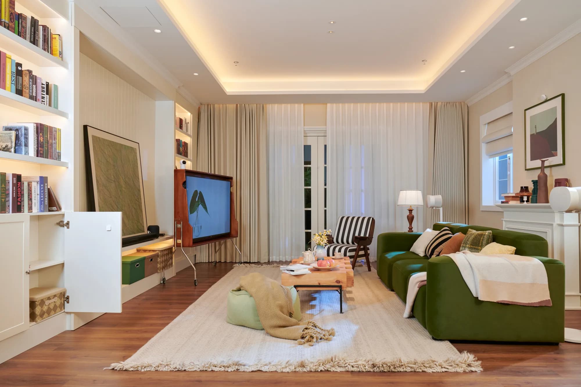 Warm living room with a green sofa, built-in shelves and layered lighting