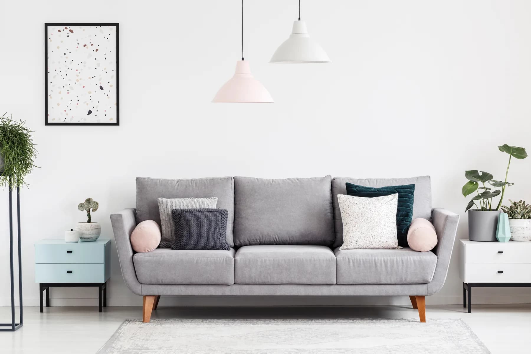 Bright living room with a pale grey sofa and pastel side tables